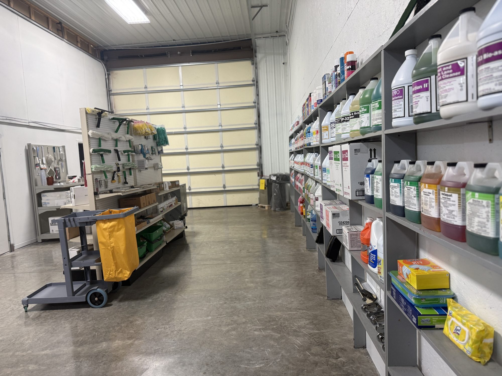 Warehouse aisle lined with cleaning chemical shelves